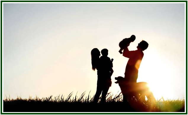 Silhuetas escuras de um casal feliz com os seus dois filhos pequenos e um cão num campo aberto de relva, celebrando a harmonia familiar sob a forte e radiosa luz dourada do pôr do sol, refletindo a atmosfera pacífica estudada na teosofia.